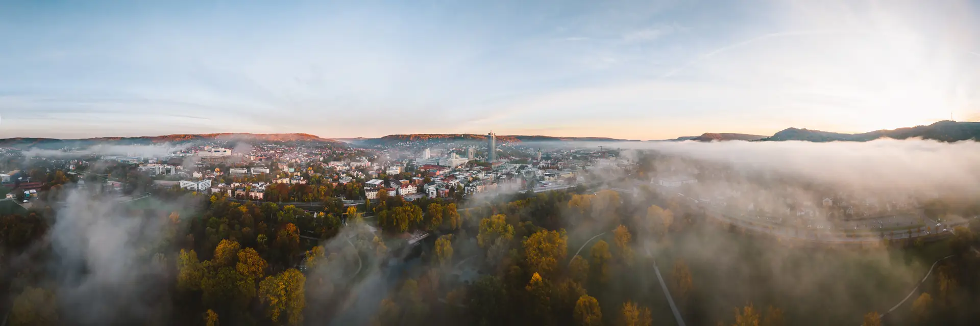 Jena im Herbstnebel, nur der JenTower und die Hänge ragen aus der Nebeldecke